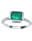 This inexpensive emerald ring displays the topside view of the bezel set emerald and accent diamonds on the band.