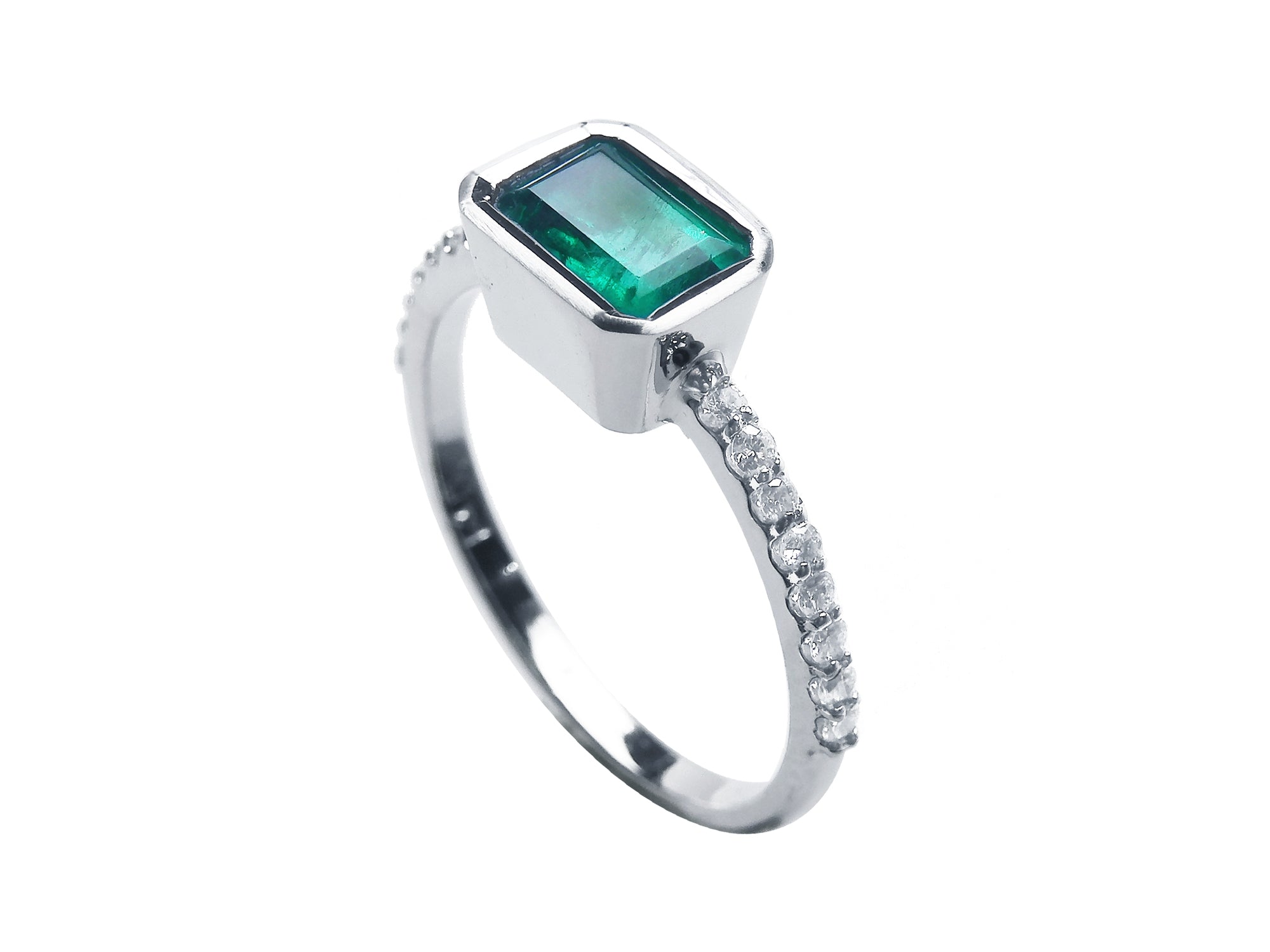 A clean side profile perspective of this natural emerald ring crafted in 14K white gold.