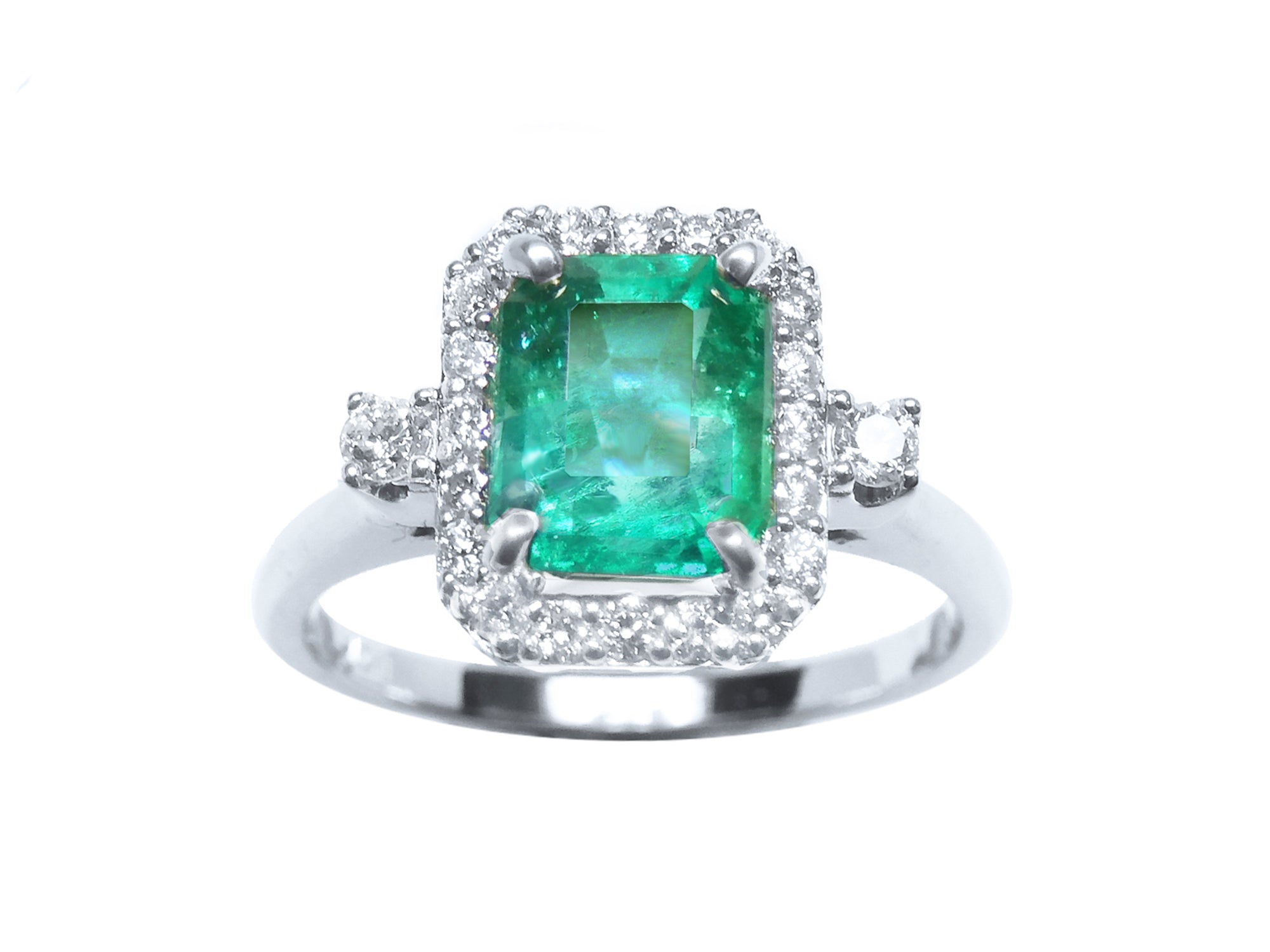 This inexpensive emerald engagement ring with a halo diamond displays the topside view.