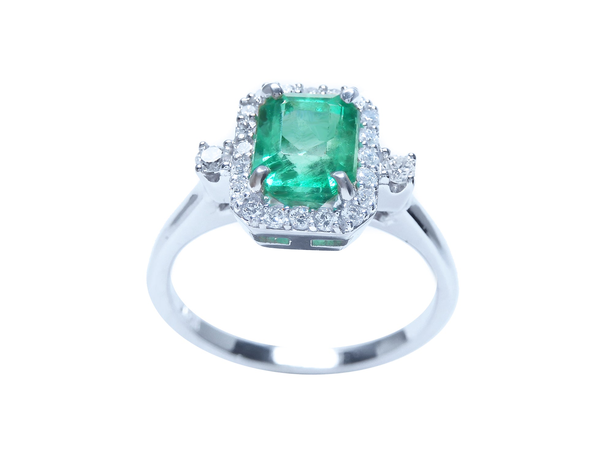 The top and band ring perspective of an emerald engagement ring with a halo diamond.