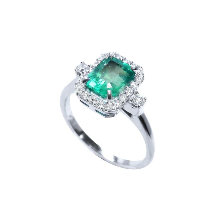 1.47 ct emerald cut emerald ring with diamond halo in 14K white gold.