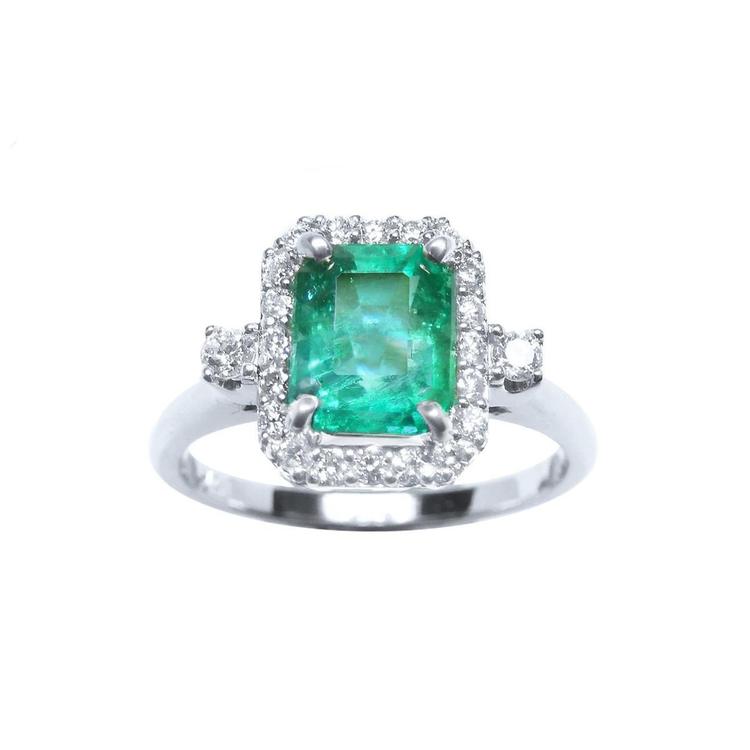 This inexpensive emerald engagement ring with a halo diamond is made of 14k white gold.