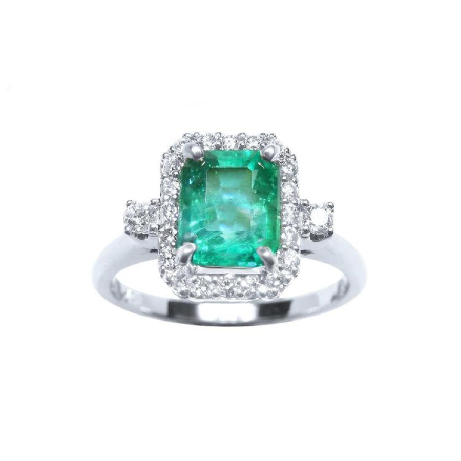 This inexpensive emerald engagement ring with a halo diamond is made of 14k white gold.