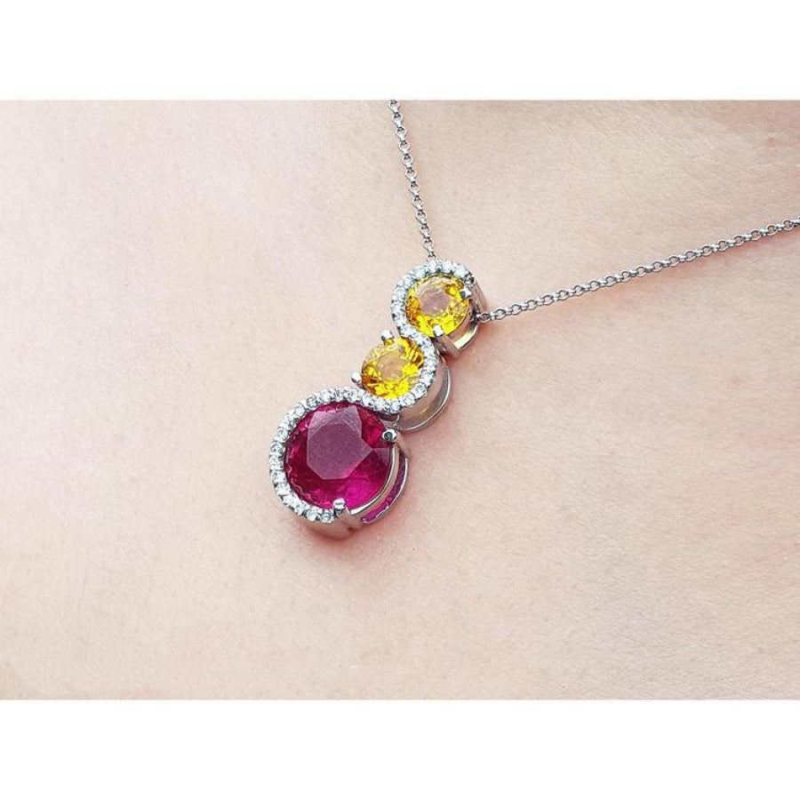 14K white gold ruby journey pendant with two yellow sapphires and diamond accents.