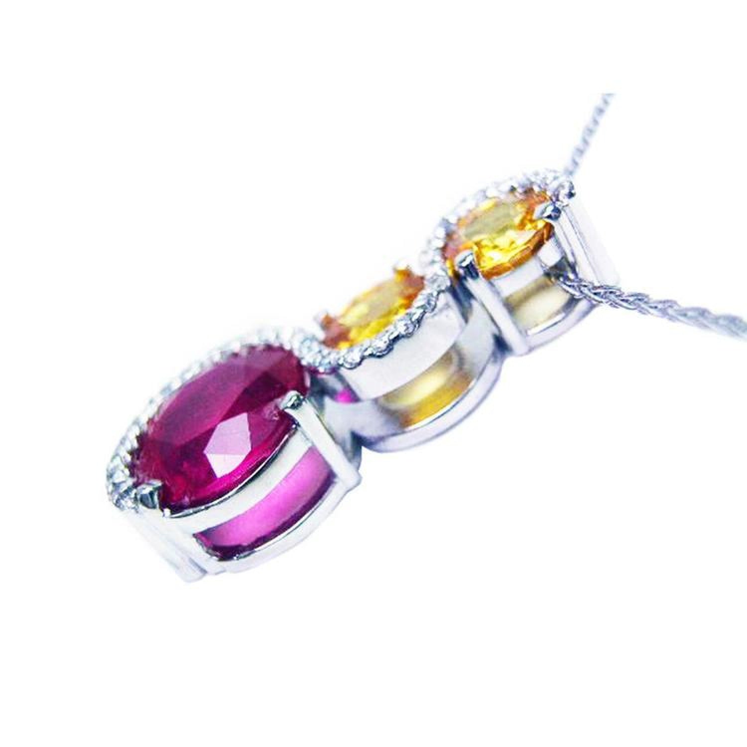 14K white gold ruby journey pendant with oval ruby, two yellow sapphires, and diamond accents.
