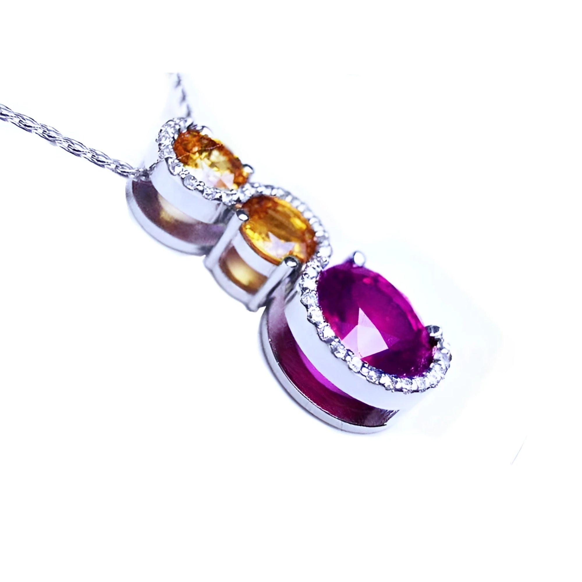 14K white gold ruby journey pendant with two yellow sapphires and diamond accents.