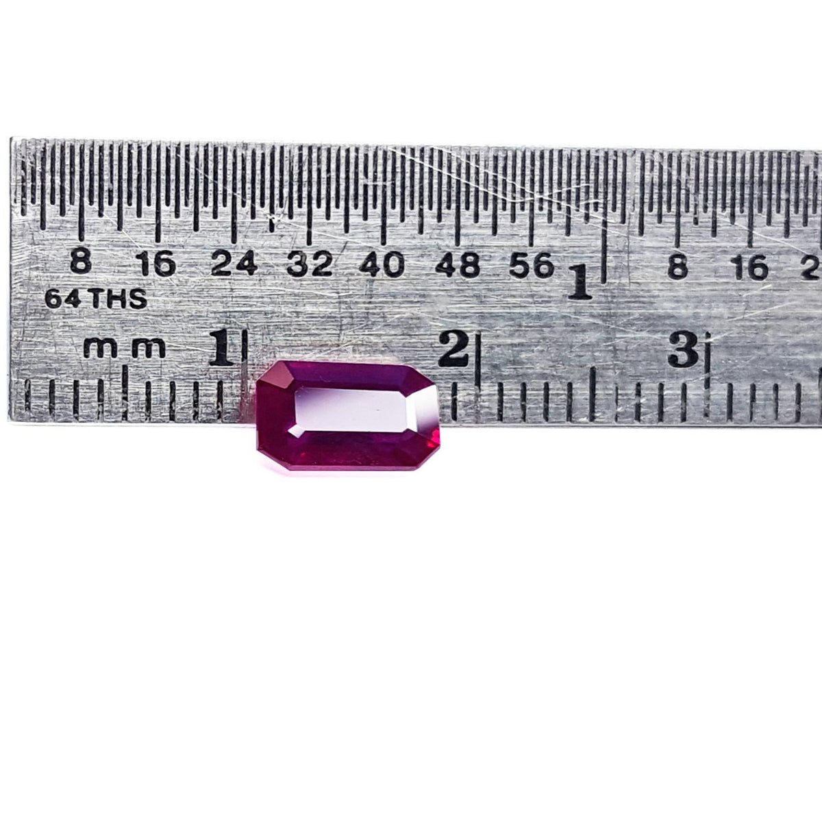 Rectangular natural ruby Burma emerald-cut table and crown visibles on a ruler for scale measurement