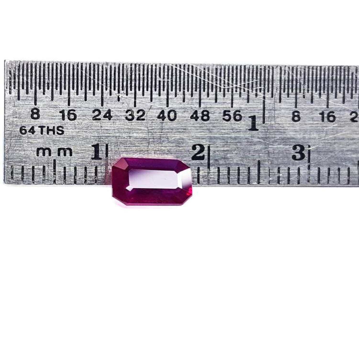 1.12 ct deep red emerald-cut natural ruby gemstone next to a ruler for scale.