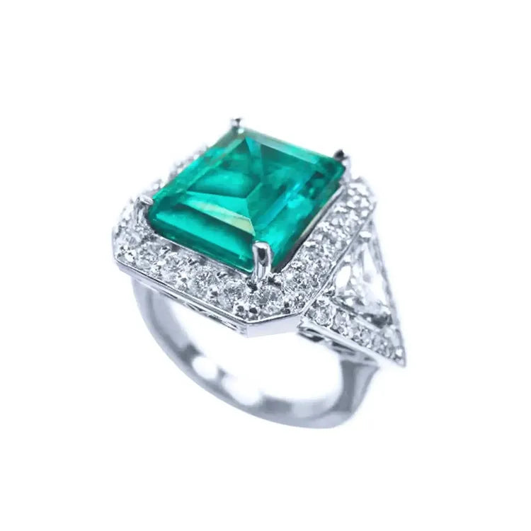 en posición de perfil se ve una esmeralda rodeada por diamantes de un anillo para mujer.