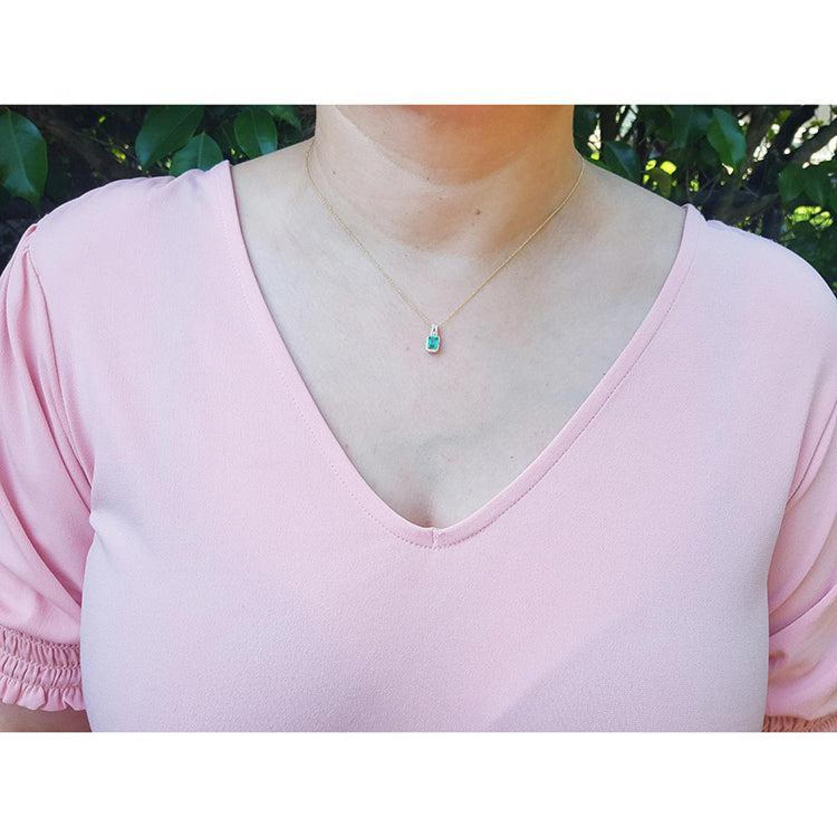 Ladies' 14K gold necklace with emerald-cut Colombian emerald slider pendant and halo diamonds.