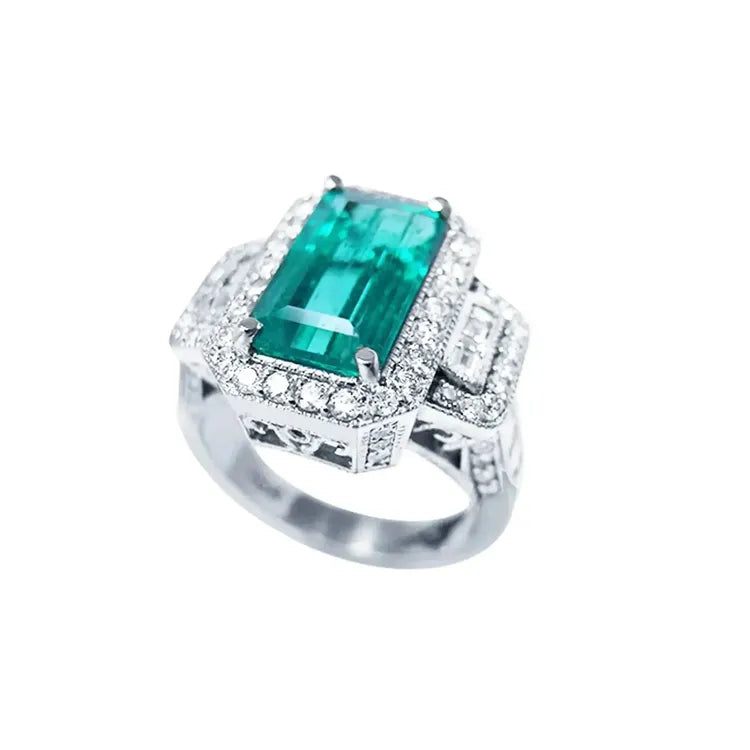 Anillo de compromiso de oro blanco 18k con esmeralda colombiana rectangular de 2.99 ct y diamantes.
