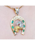 18K yellow gold horseshoe pendant with emeralds, diamonds, and horse head design.