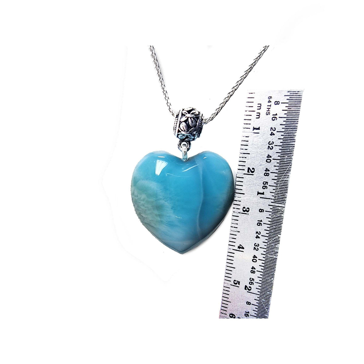 Larimar heart-shaped pendant on a silver chain with a ruler for scale on a white background