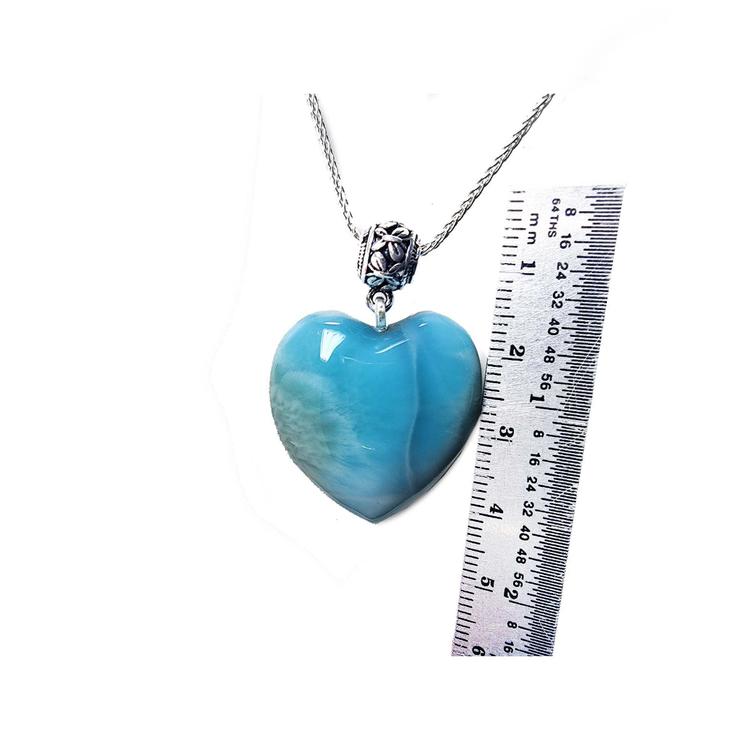 Larimar heart-shaped pendant on a silver chain with a ruler for scale on a white background