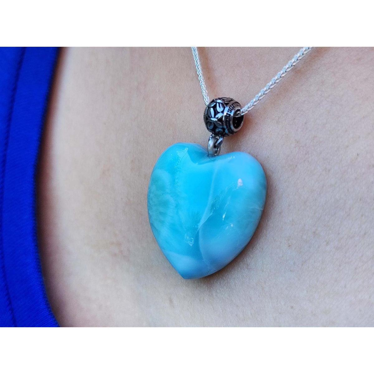Larimar heart-shaped pendant on a necklace against a person's neck