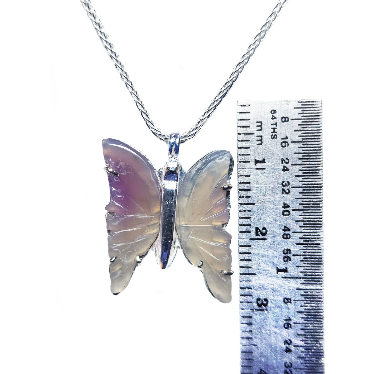 Butterfly agate pendant silver necklace with a ruler for scale on a white background