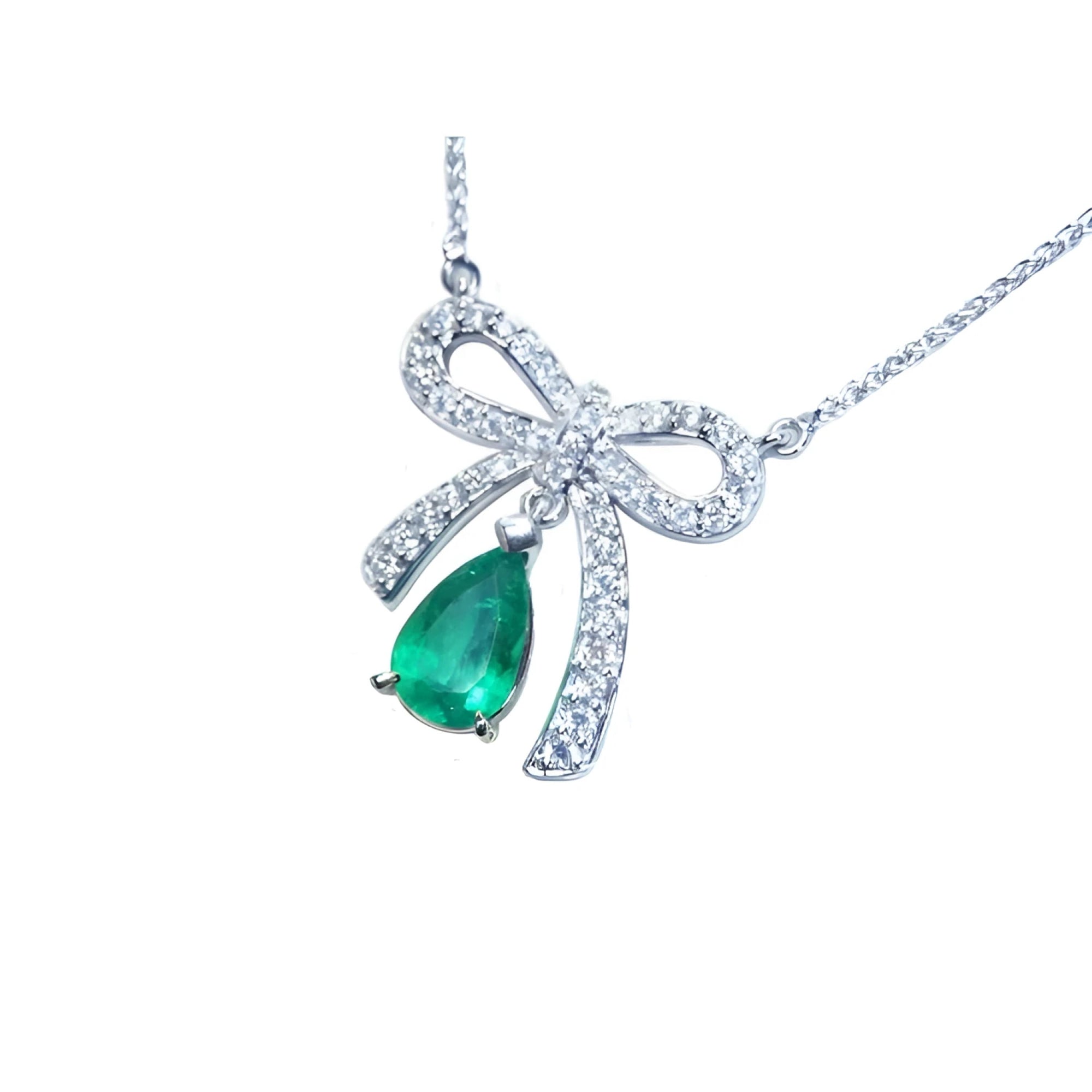 18K white gold bow-tie necklace with a pear-shaped deep green emerald.