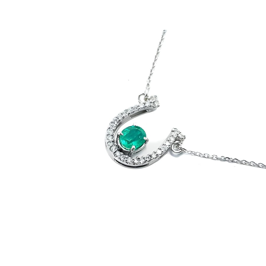14K white gold horseshoe necklace with oval emerald and natural diamonds.