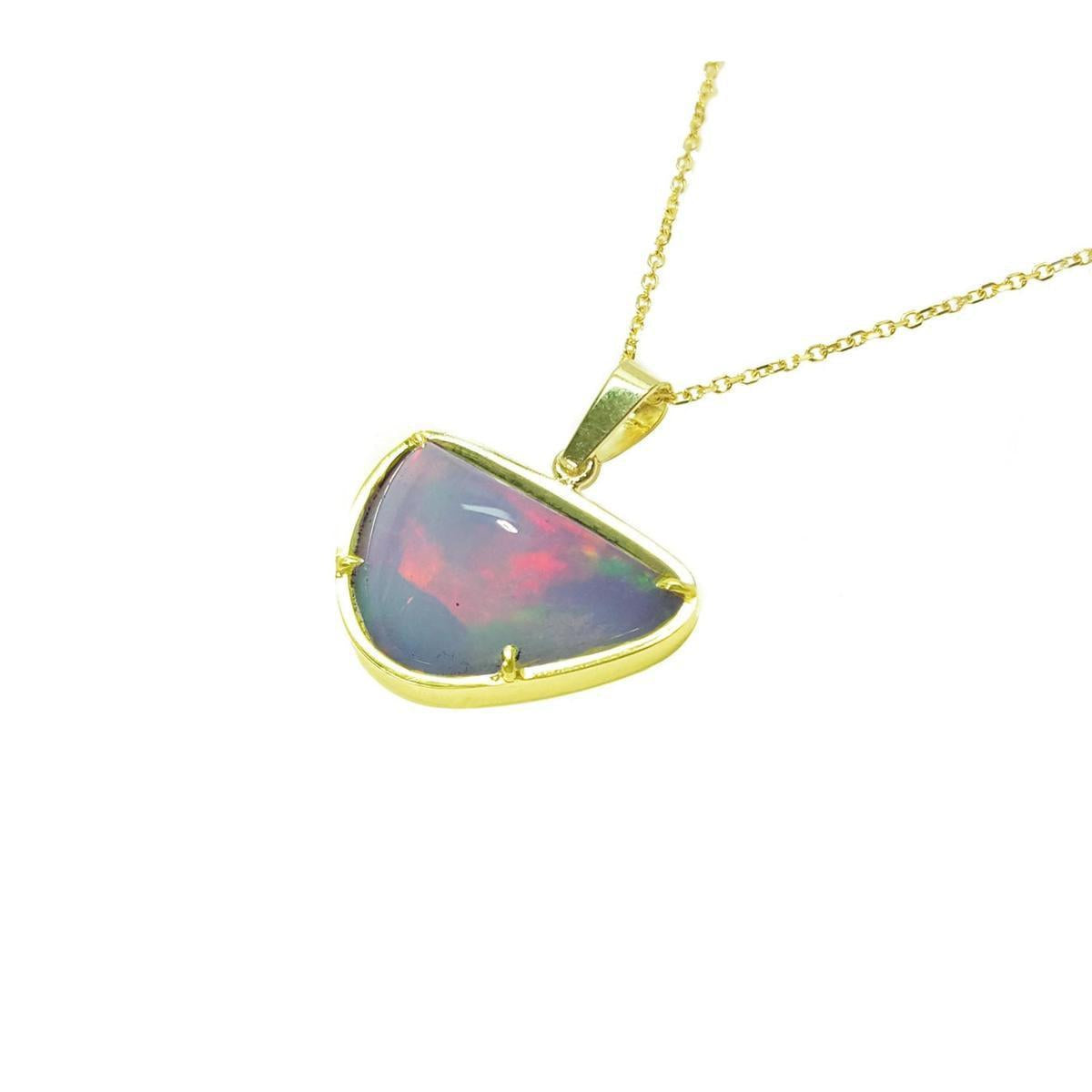 Opal pendant on a gold chain on a left-side profile against a white background.