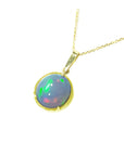 Welo Ethiopian opal pendant necklace on a gold chain against a white background.