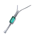 left side view of a white gold emerald necklace elongated emerald-cut natural Muzo mines in a white background