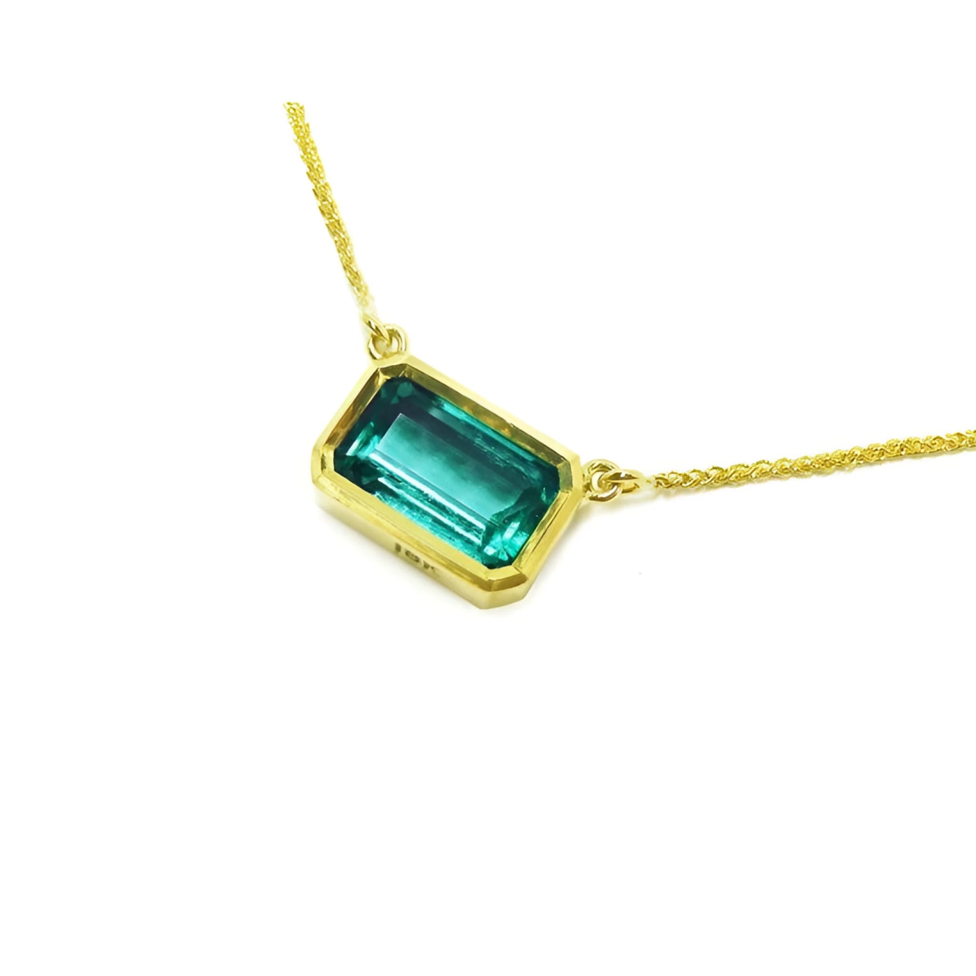 East-west rectangular emerald solitaire necklace in 18K yellow gold.