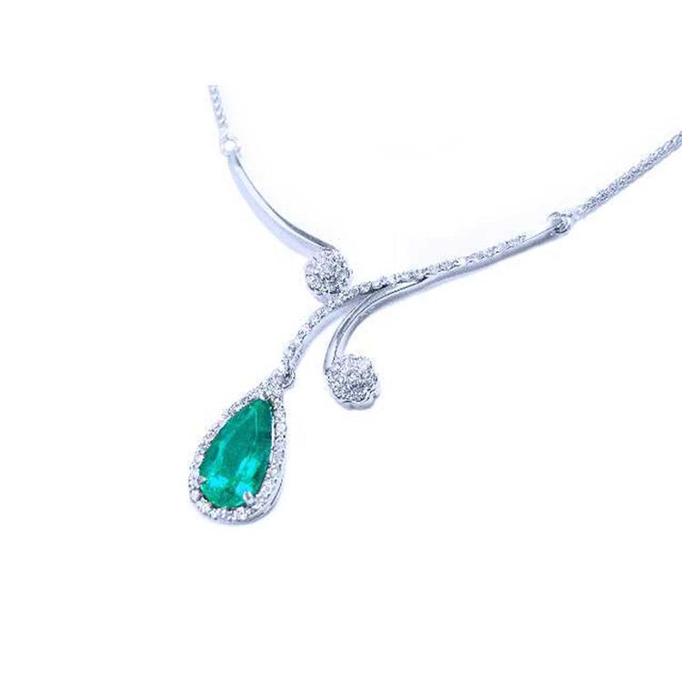 Left side of a white gold necklace with an emerald teardrop halo diamond pendant on a white background