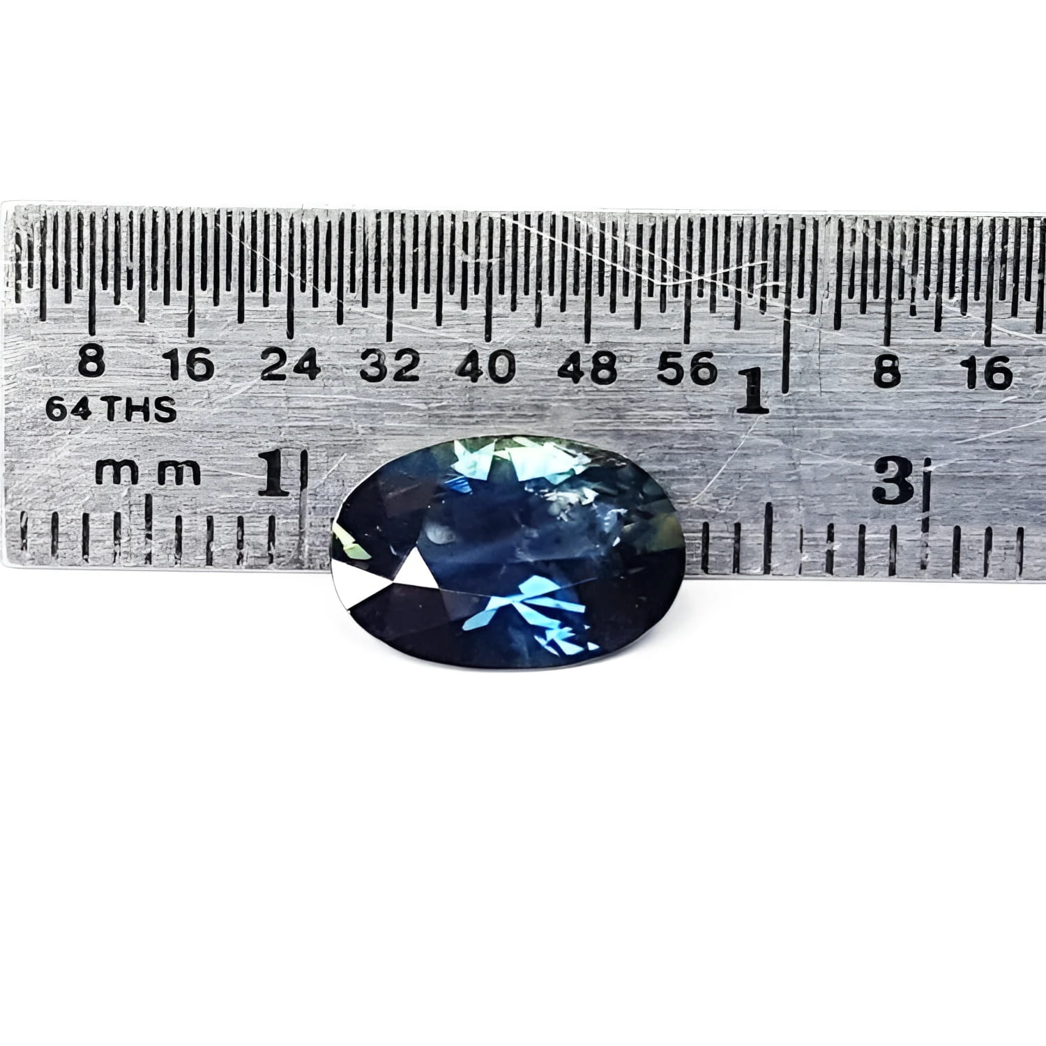3.04 ct. deep blue-green oval cut natural Australian loose sapphire next to a ruler.