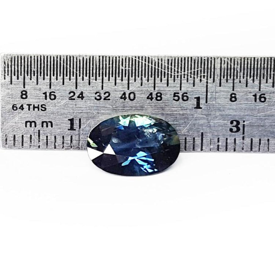 3.04 ct. deep blue-green oval cut natural Australian loose sapphire next to a ruler.