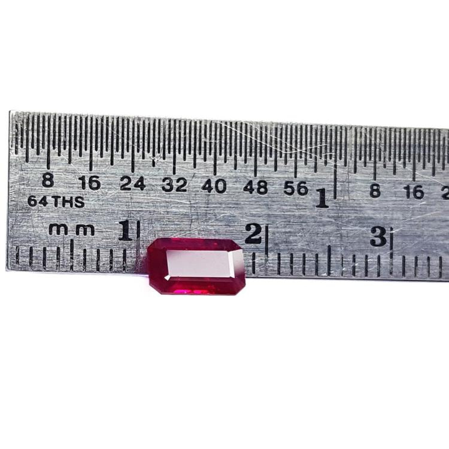 1.08 carat emerald cut Burma ruby with deep rich red color, measured on a ruler.
