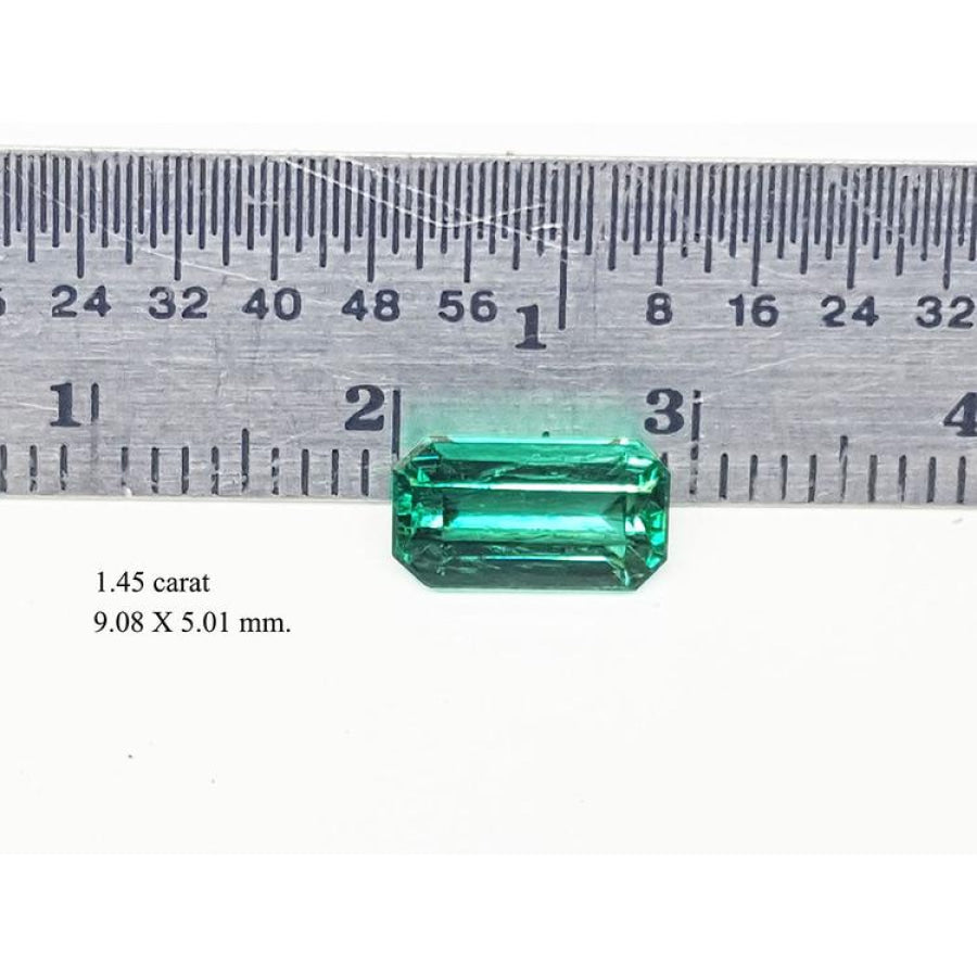 1.45 carat emerald gemstone, 9.08 X 5.01 mm, shown with a ruler for scale.
