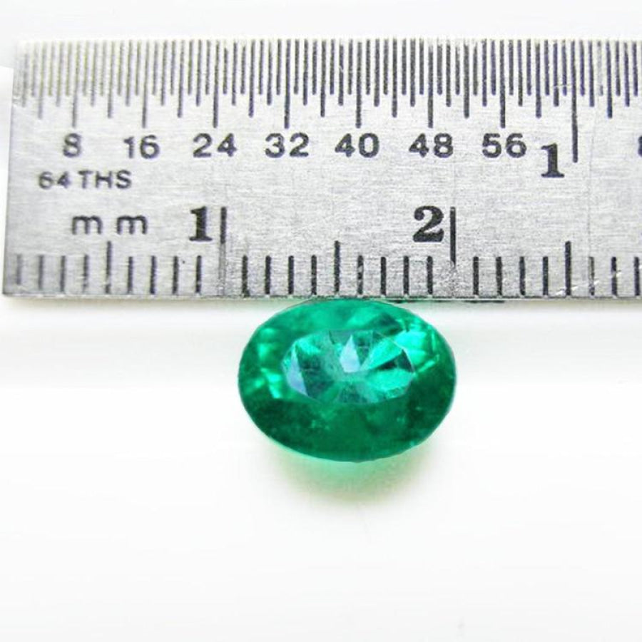 2.11 ct oval cut deep bluish-green Colombian emerald next to a ruler for scale.