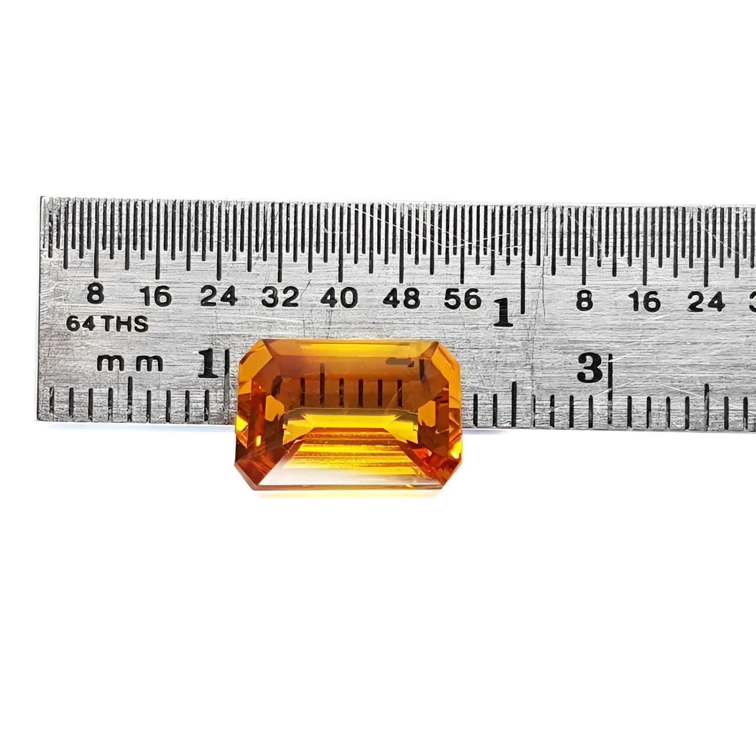 4.05 ct. vibrant intense yellow emerald-cut natural sapphire gemstone next to a ruler.