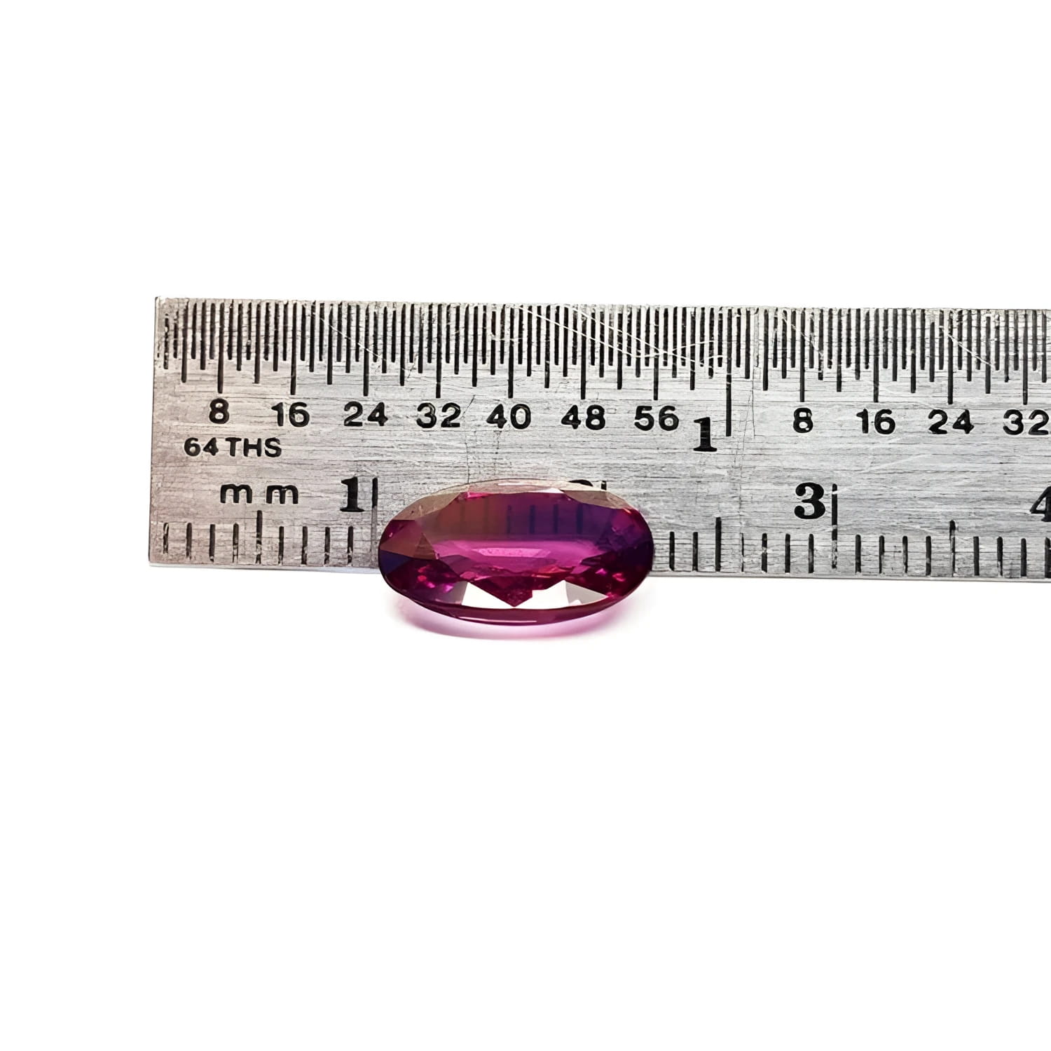 3.51 ct. natural medium pink oval sapphire with intense brilliance next to a ruler.