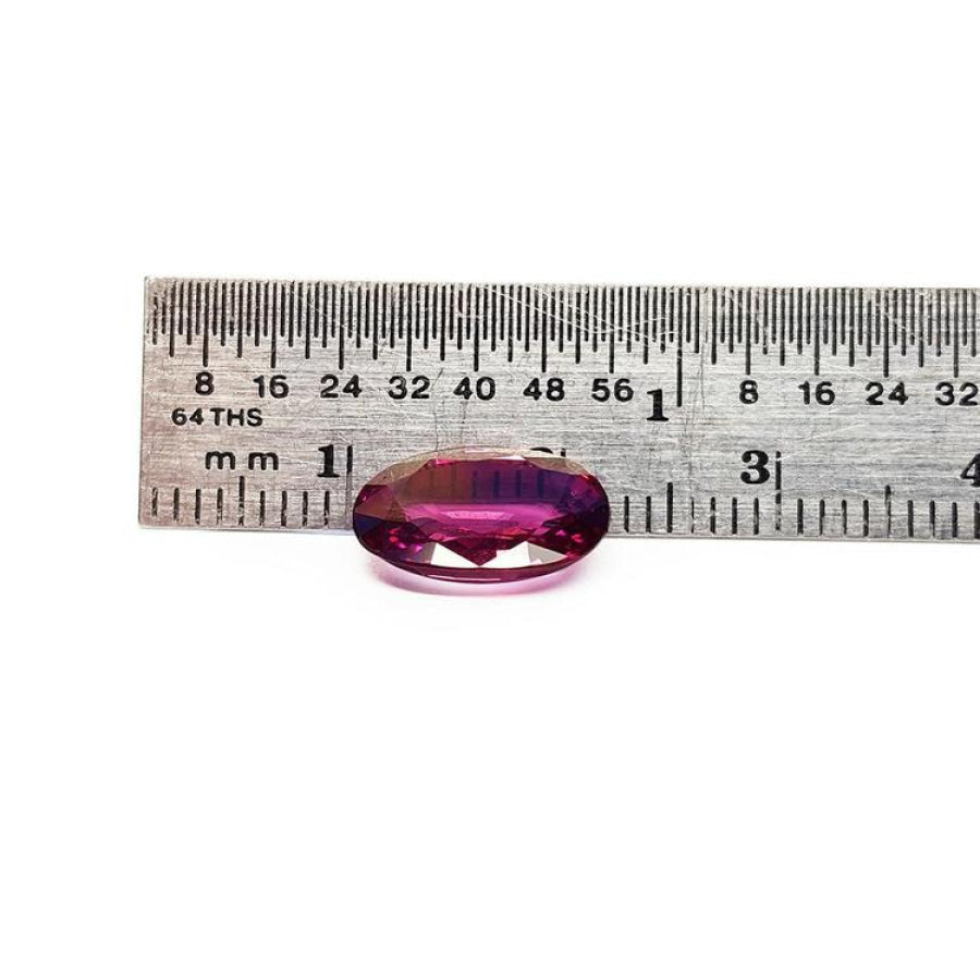 3.51 ct. natural medium pink oval sapphire with intense brilliance next to a ruler.