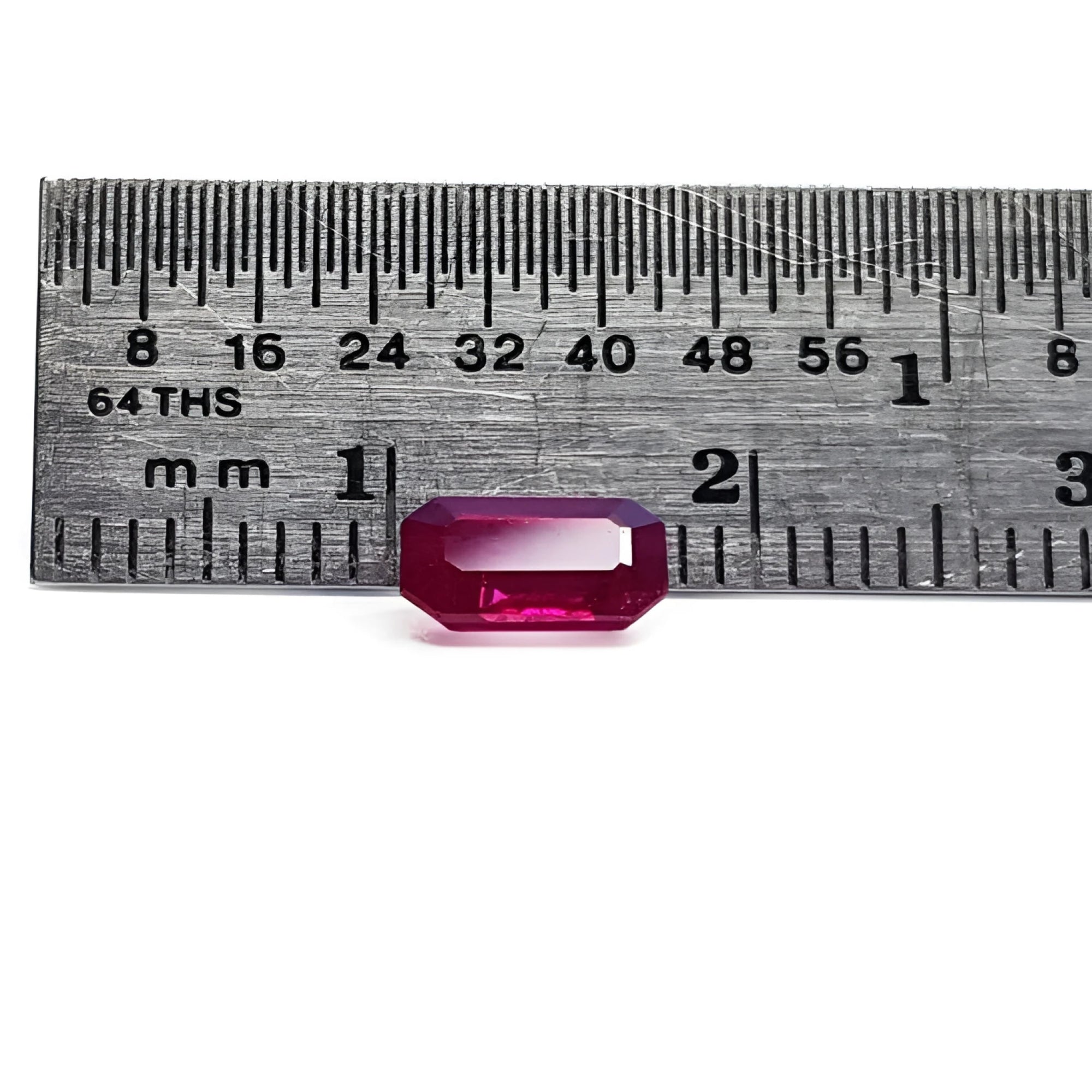 0.95 carat natural Burma ruby, emerald cut, displayed next to a ruler for scale.