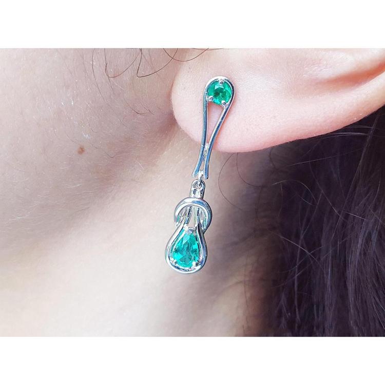White gold with Love Knot Colombian emerald earring worn by a person