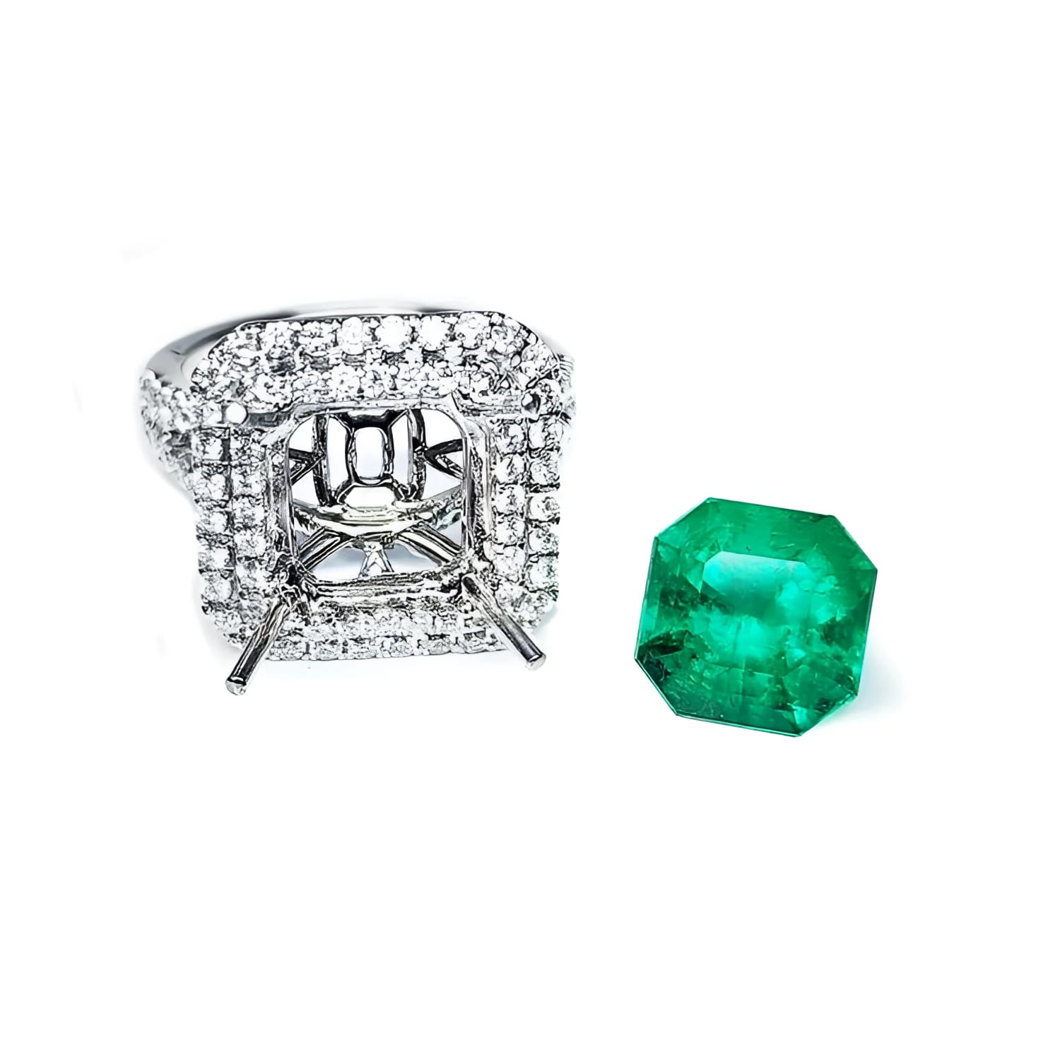 14K white gold diamond halo ring setting next to a loose, bright medium green Colombian emerald.