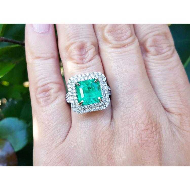 4.14 ct GIA-certified F1 Colombian emerald ring with diamonds in 14K white gold on a hand.