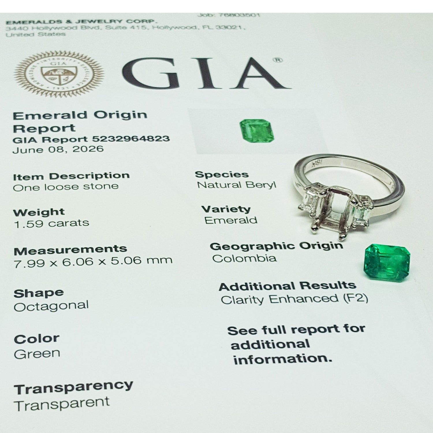 Emerald ring with GIA report on a white background