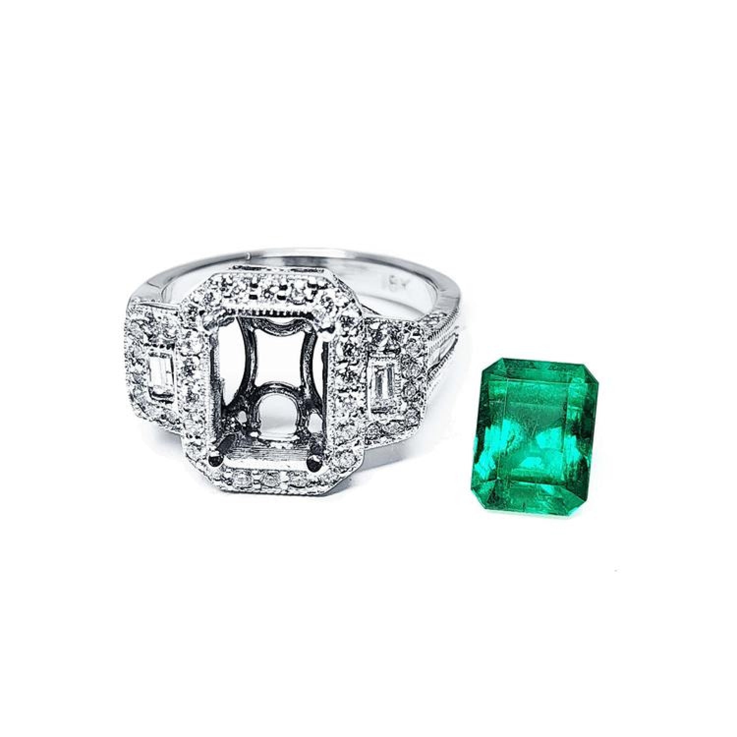 18K white gold engagement ring setting with diamond halo and baguette side diamonds, next to a vibrant emerald.