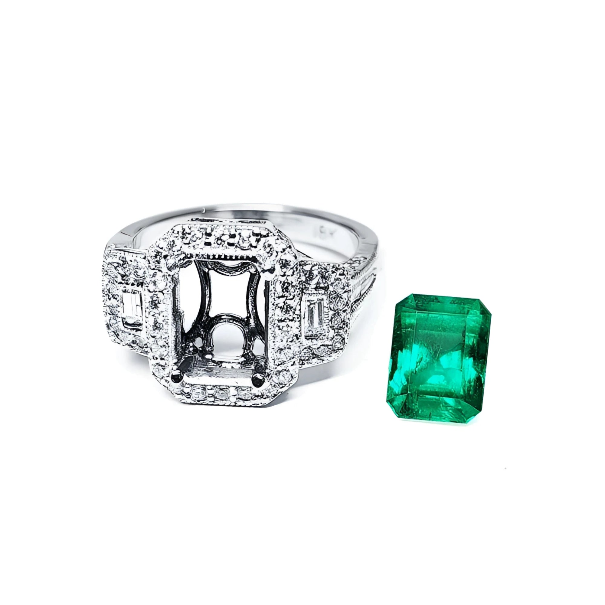 18K white gold engagement ring setting with diamond halo and baguette side diamonds, next to a vibrant emerald.