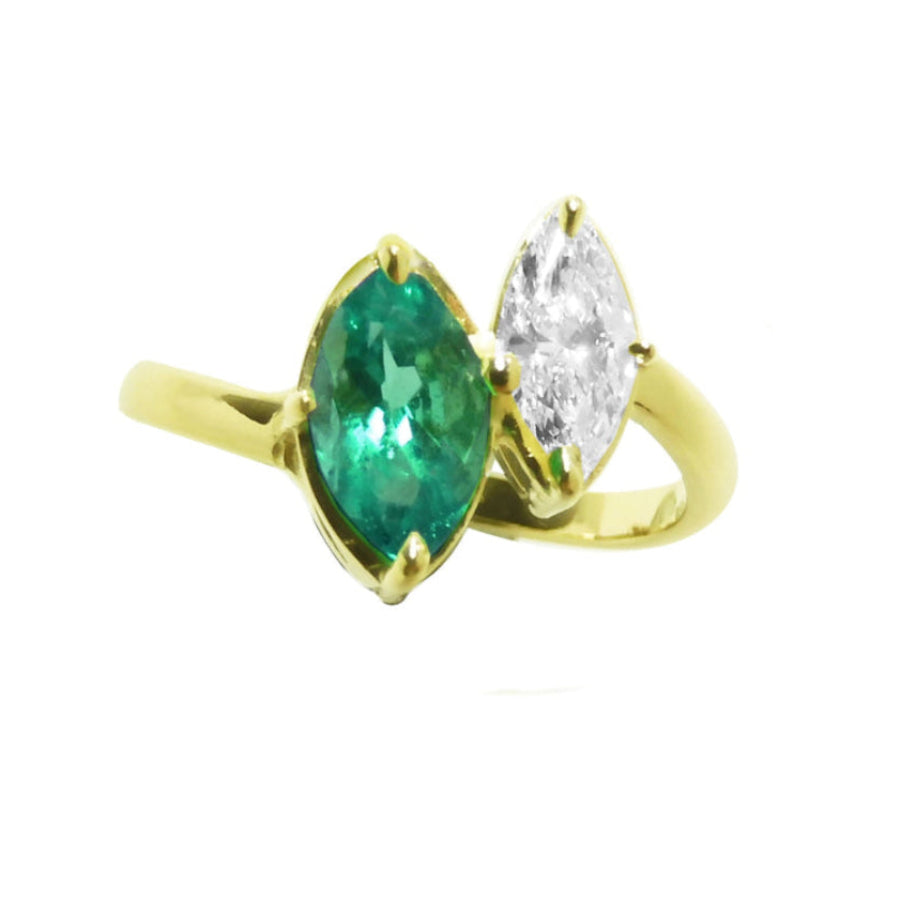 A 18k yellow gold you and me ring featuring a marquise-cut natural emerald and a marquise-cut diamond, toi et moi design.