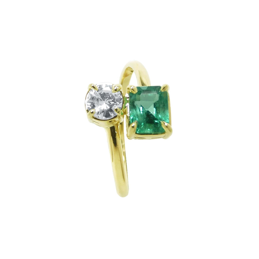 A 18k yellow gold ring featuring a round-cut diamond and a rectangular emerald-cut gemstone toi et moi design.