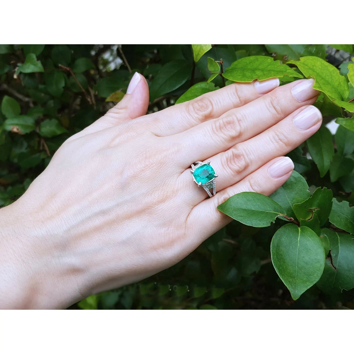 Anillo con esmeralda para bodas elaborado en oro blanco de 18k, exhibido en una mano de mujer.
