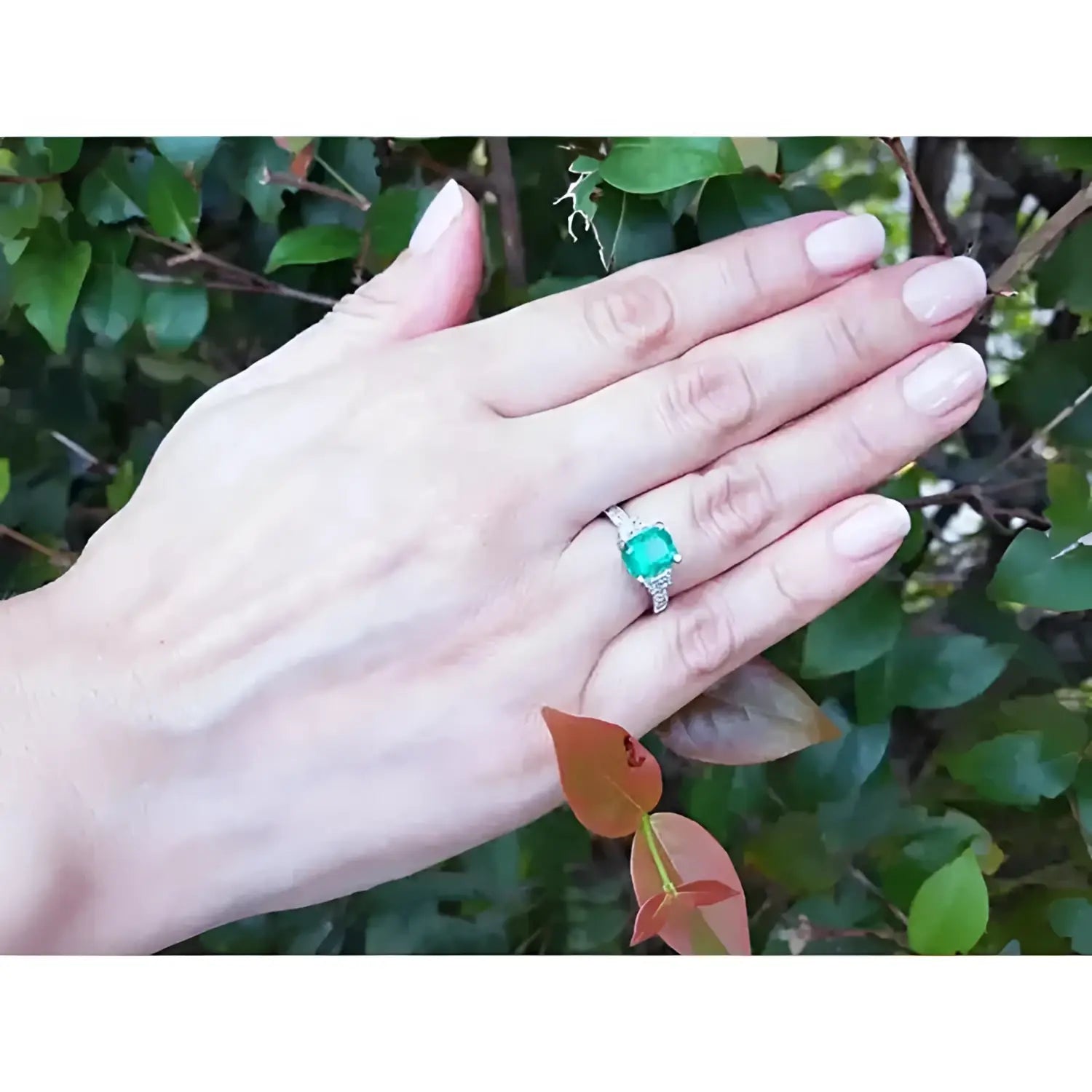 Anillo de compromiso de oro blanco 18k con esmeralda colombiana y diamantes trapezoide.
