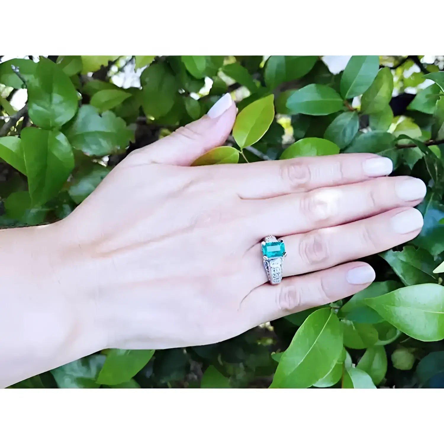 Anillo de oro blanco 18K con esmeralda colombiana rectangular verde profundo y diamantes, estilo antiguo.