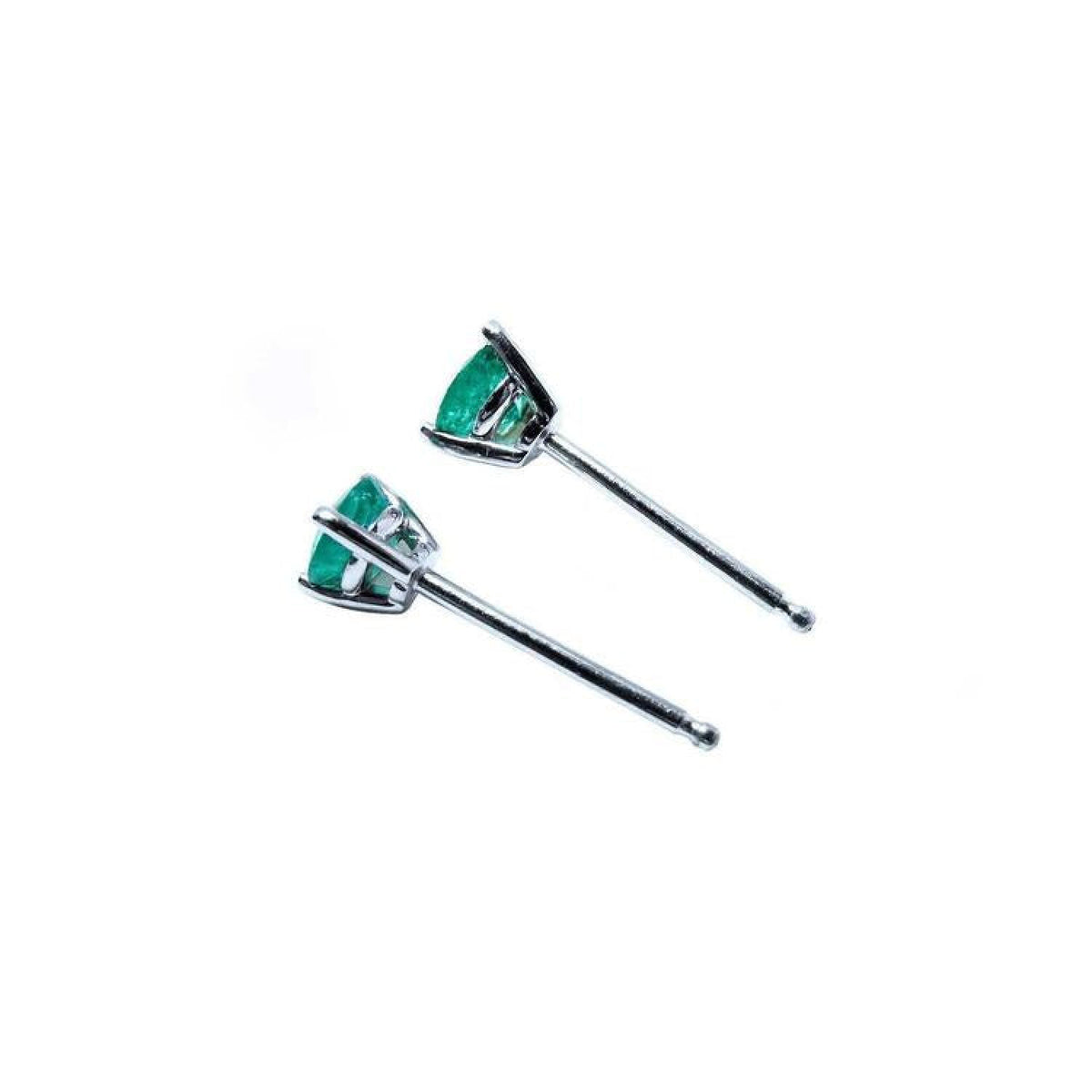 Pair of 14K white gold Martini stud earrings with round cut green emeralds, three-prong set.
