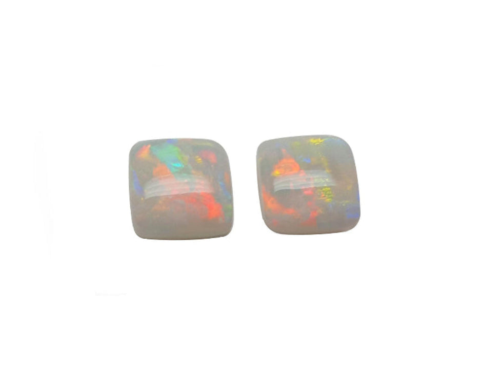 A matching pair for earrings of solid Australian opals multicolor hues cabochon square shaped, topside dome view.