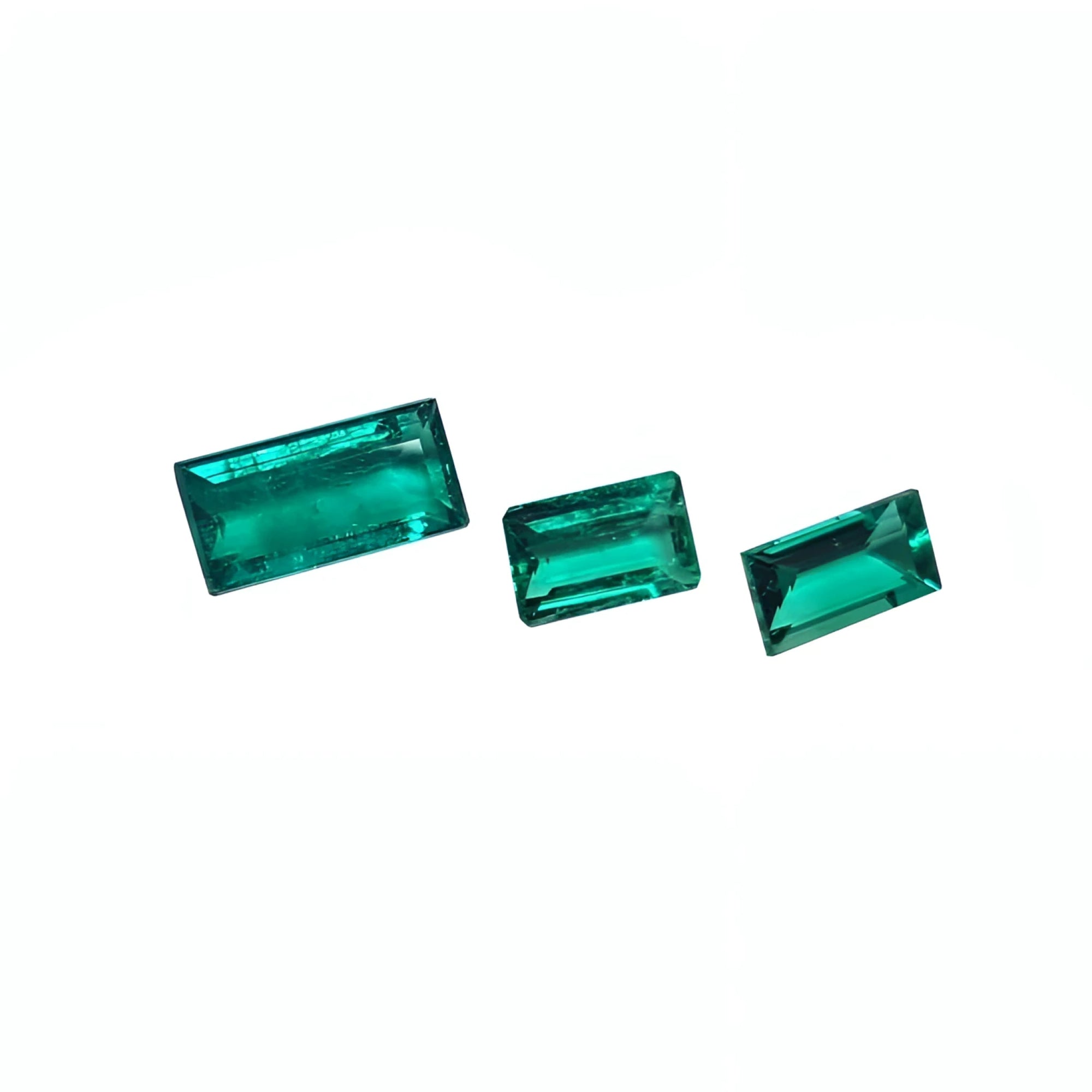 Three baguette-cut natural loose Colombian emeralds, vibrant deep bluish-green.